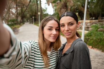 Naklejka premium Two young women taking a selfie with her phone