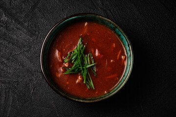 Korean Kimchi soup in black bowl on black concrete background