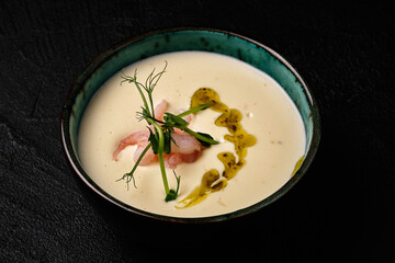 Bowl of Cheese soup with shrimps on black background