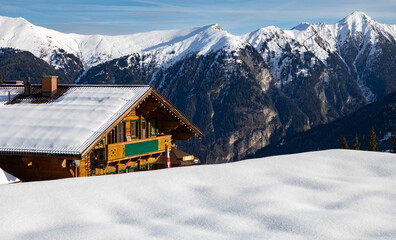 A small hut stands on a high point in the mountains, Austrian Alps