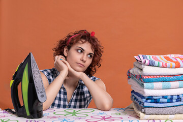 A young woman glances at a folded pile of ironed and fragrant towels.