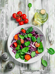 Vegetable salad. Red cabbage, tomato and spinach salad with olive oil.