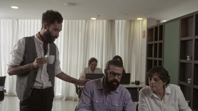 Latin Man Helping Coworkers At Office