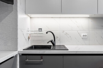 Black shell and matte black crane located on white surfaces of porcelain plates that imitate the...