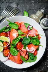 Fish salad. Salad with slices of salmon, tomatoes and spinach with lime juice.