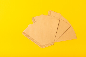 Coffee filters on a yellow textural background.