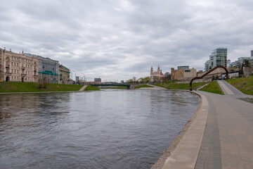 Fototapeta premium Church of St. Archangel Raphael in the distance and some modern buildings along river Neris.