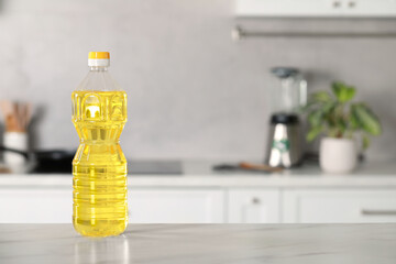 Bottle of cooking oil on white marble table in kitchen. Space for text