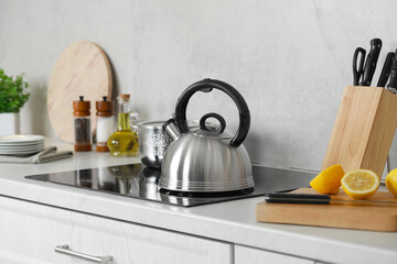 Stylish kettle with whistle on cooktop in kitchen