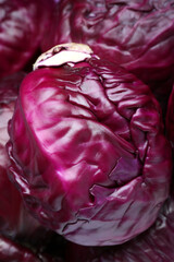 Fototapeta premium Fresh ripe red cabbages as background, top view