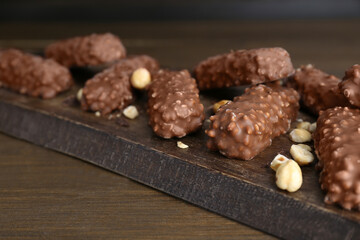 Tasty sweet chocolate bars on wooden table, closeup