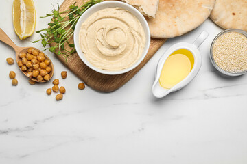 Delicious hummus and different ingredients on white marble table, flat lay. Space for text