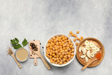 Delicious chickpeas and different ingredients on light grey table, flat lay with space for text. Cooking hummus