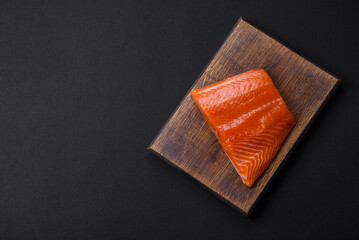 Fillet of raw red salmon fish with salt, spices and herbs