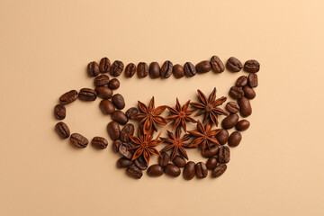 Cup made with coffee beans and anise stars on beige background, flat lay