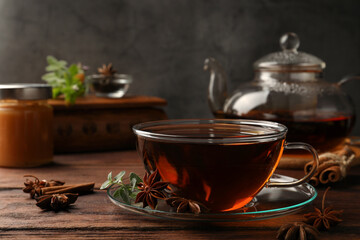 Aromatic tea with anise stars and mint on wooden table. Space for text