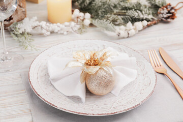 Festive place setting with beautiful dishware, cutlery and decor for Christmas dinner on white wooden table