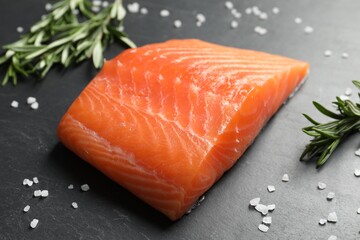 Fresh raw salmon and ingredients for marinade on black table