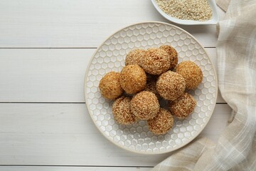 Delicious sesame balls on white wooden table, flat lay. Space for text