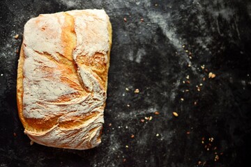 Bakery products. Crispy, beautiful bread on a dark background. Top view, place for text.