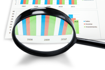 Checking business balance concept, Magnifying Glass with report
