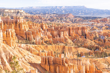 Winter scenery from Bryce Canyon National Park with brilliantly colored orange cliffs and a touch...
