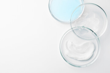 Many Petri dishes and cosmetic products on white background, top view