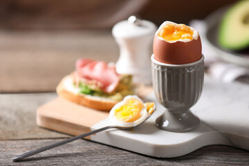 Soft boiled chicken egg served on wooden table, space for text