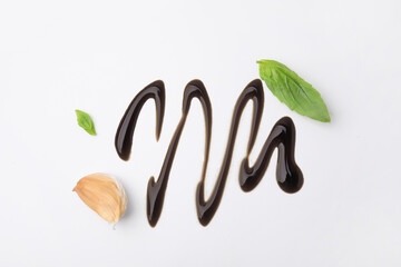 Organic balsamic vinegar, garlic and basil leaves on white background, flat lay