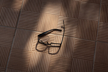 a broken eyeglass frame lies on a street ribbed tile in a beautiful shade from trees on a sunny day. High quality photo