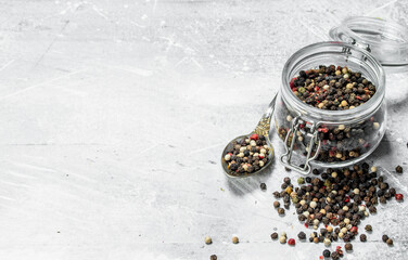 Fototapeta na wymiar Peas pepper in a glass jar with a spoon.