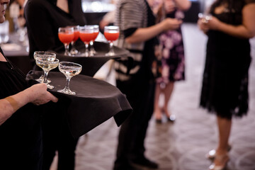 Servers holding trays of drinks at a fancy party