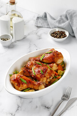 Roasted Baked chicken legs drumsticks with vegetables on baking dish on the table. Meal, dinner diet concept, diet.