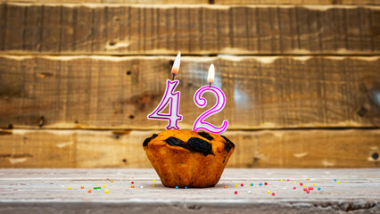 Muffin with candle burning background for anniversary. Greeting card for the holiday. Happy...