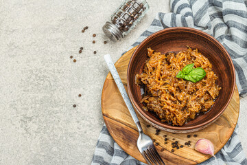 Stewed cabbage ready for eating. Homemade braised vegan food. Spices, herbs, cutlery