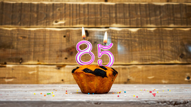 Muffin with candle burning background for anniversary. Greeting card for the holiday. Happy birthday background minimalist copy space 85
