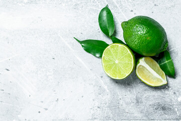 Whole and pieces of fresh lime with leaves.