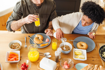 High angle view of biracial young couple having breakfast together on dining table at home