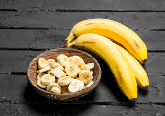 Juicy fresh bananas and banana slices in a plate.