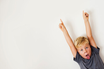 cheerful  boy pointing fingers over white background