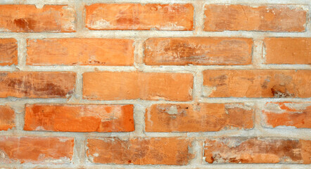 Background texture of a red brick wall with gray cement between them.