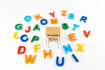 Fototapeta na wymiar 玩具の勉強机とアルファベット.英語の勉強イメージ