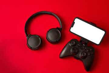Modern black gamepad for smartphone on red background. Mobile video gaming device © stenkovlad