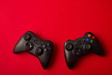 Black video game controller, joystick for game console isolated on red background. Gamer control...
