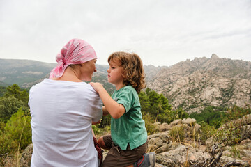 Woman with cancer relaxing in nature with her son.