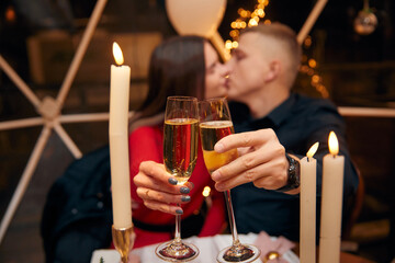 Romantic couple dating at night in restaurant, cozy atmosphere, beautiful young couple  with glasses of red wine during romantic dinner, Sweet Couple Date Dinner