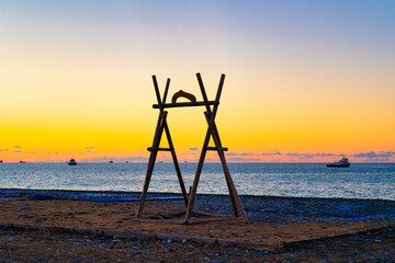 Wooden swing against the background of the sea