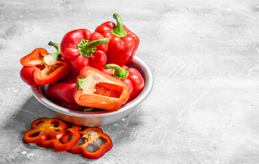 Pieces of sweet pepper and whole red peppers in the bowl.