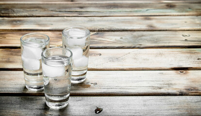 Fototapeta na wymiar Vodka in a shot glass and ice cubes.