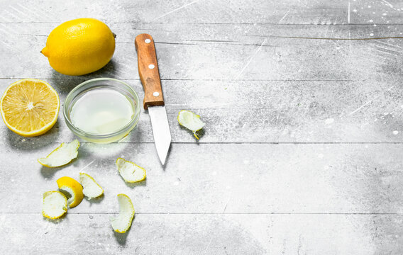 Lemon juice bowl with the zest of a lemon and a knife.